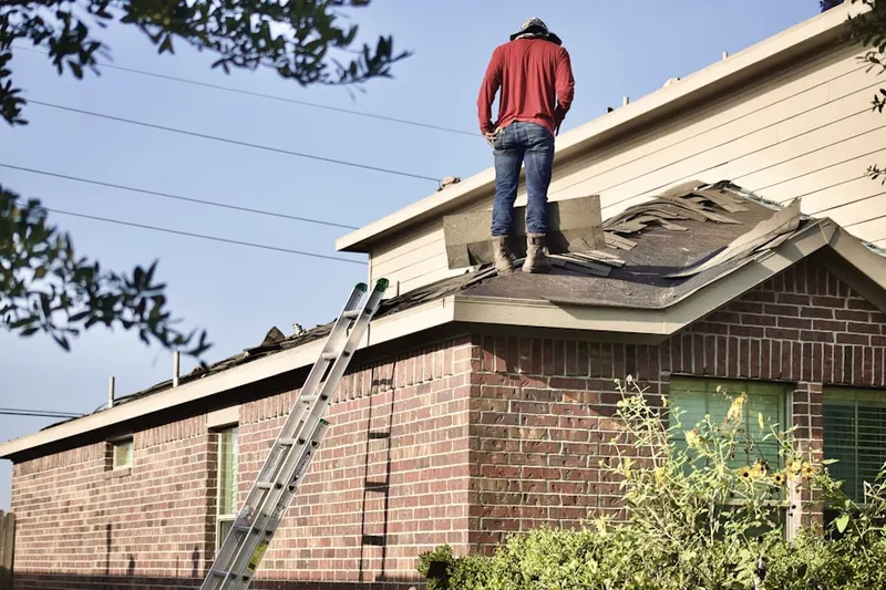 Professional roofer working on a residential roof in Hoover Woods
